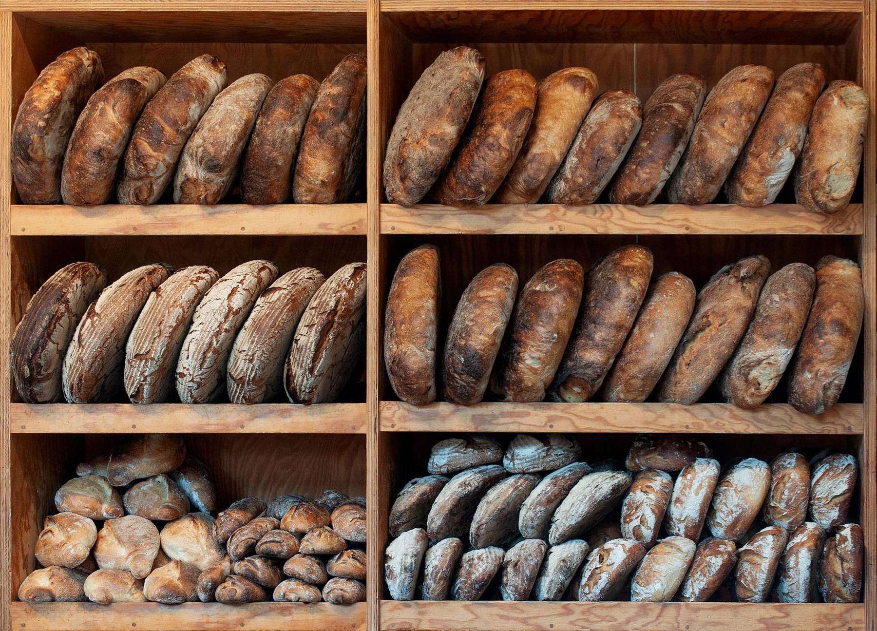 Étagères en bois garnies de pains artisanaux fraîchement cuits